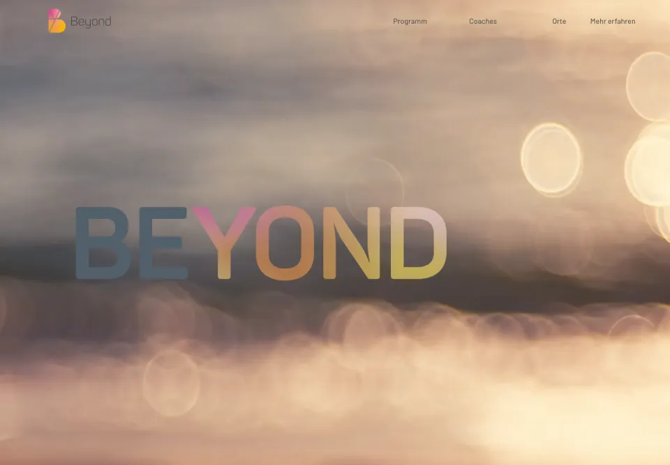 Startseite von Beyond Development am Desktop: der große Schriftzug BEYOND in Grau, Pink, Orange und Gelb vor unscharfem Wolkenlicht, oben Logo und Menü, Screenshot vom 17.10.2026