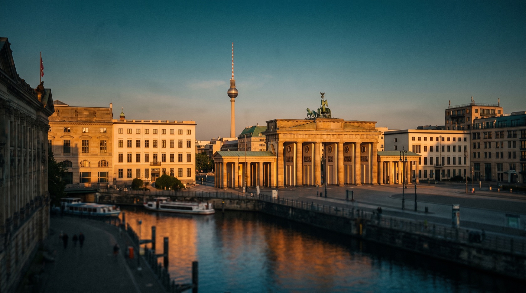 Berlin bei Abenddämmerung: das Brandenburger Tor, der Fernsehturm am Alexanderplatz und die Spree im Zentrum der Hauptstadt
