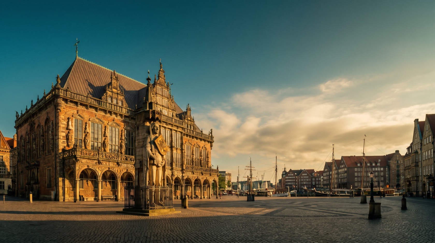 Bremen im warmen Abendlicht: das UNESCO-Rathaus mit der Roland-Statue am Marktplatz, die schmalen Gassen des Schnoor und die Überseestadt an der Weser