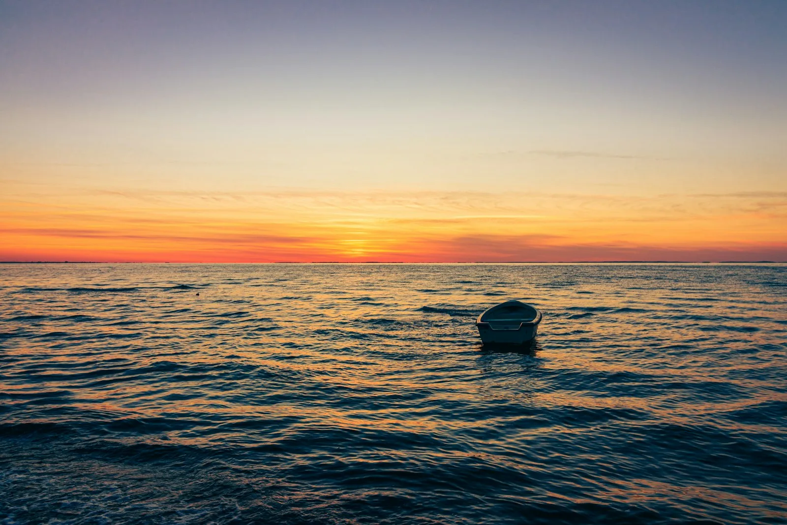 Sonnenuntergang über einem Bodden in Vorpommern mit einem Boot auf dem Wasser